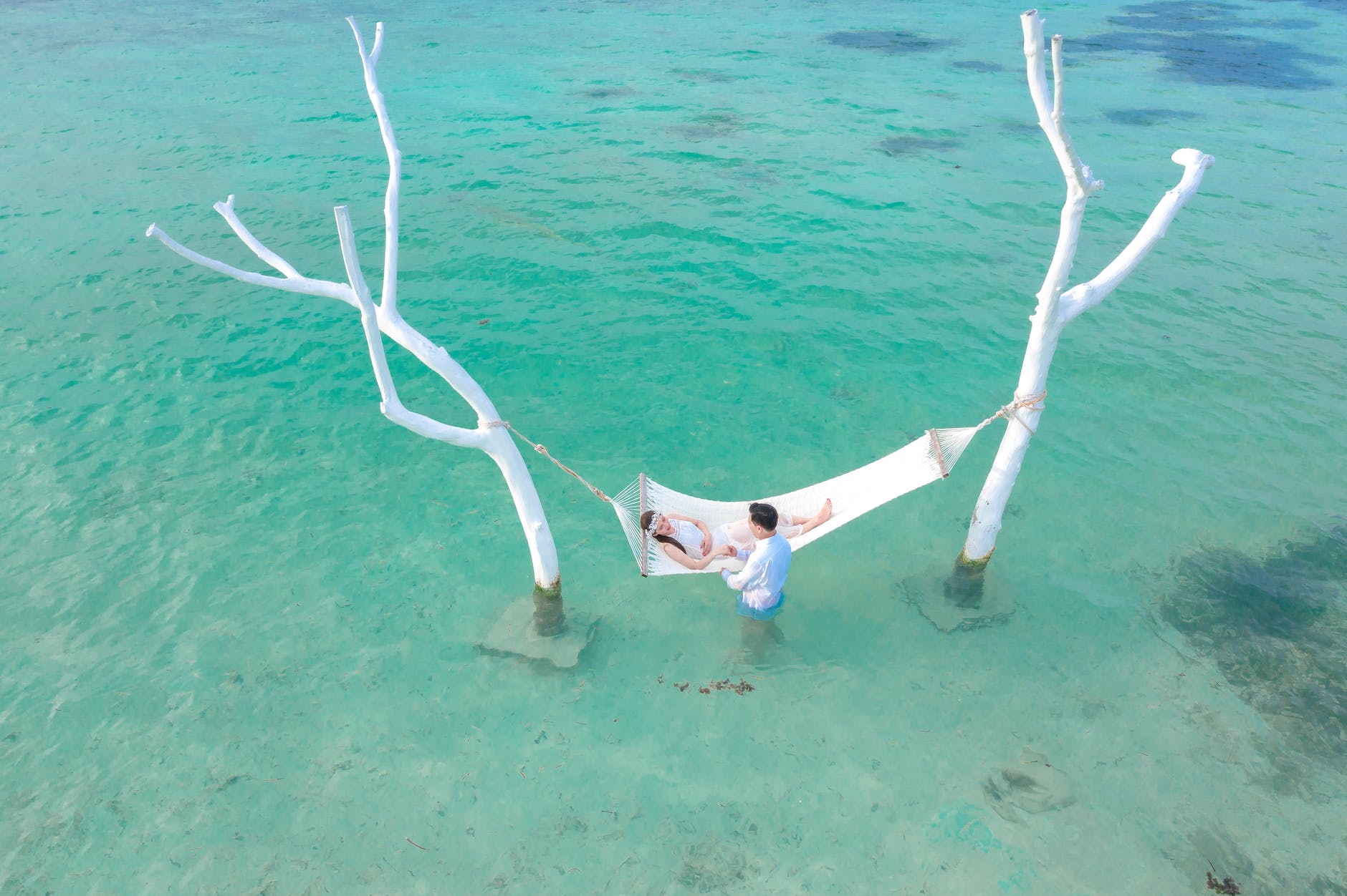 person lying on white hammock